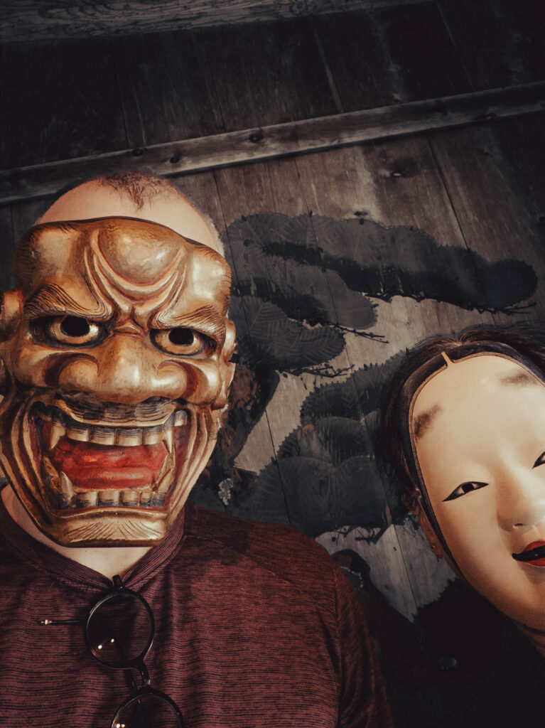 Sado Daizen Shrine Noh Stage, Takeda, Sado Island, rebuilt 1846 (photo Nov. 6, 2025): antique 獅子口 (Shishiguchi "Lion's Mouth", divine lion messenger of Bodhisattva Manjusri) nō-men., KY wearing antique 万媚 (Manbi, demon disguised as a young woman) nō-men.