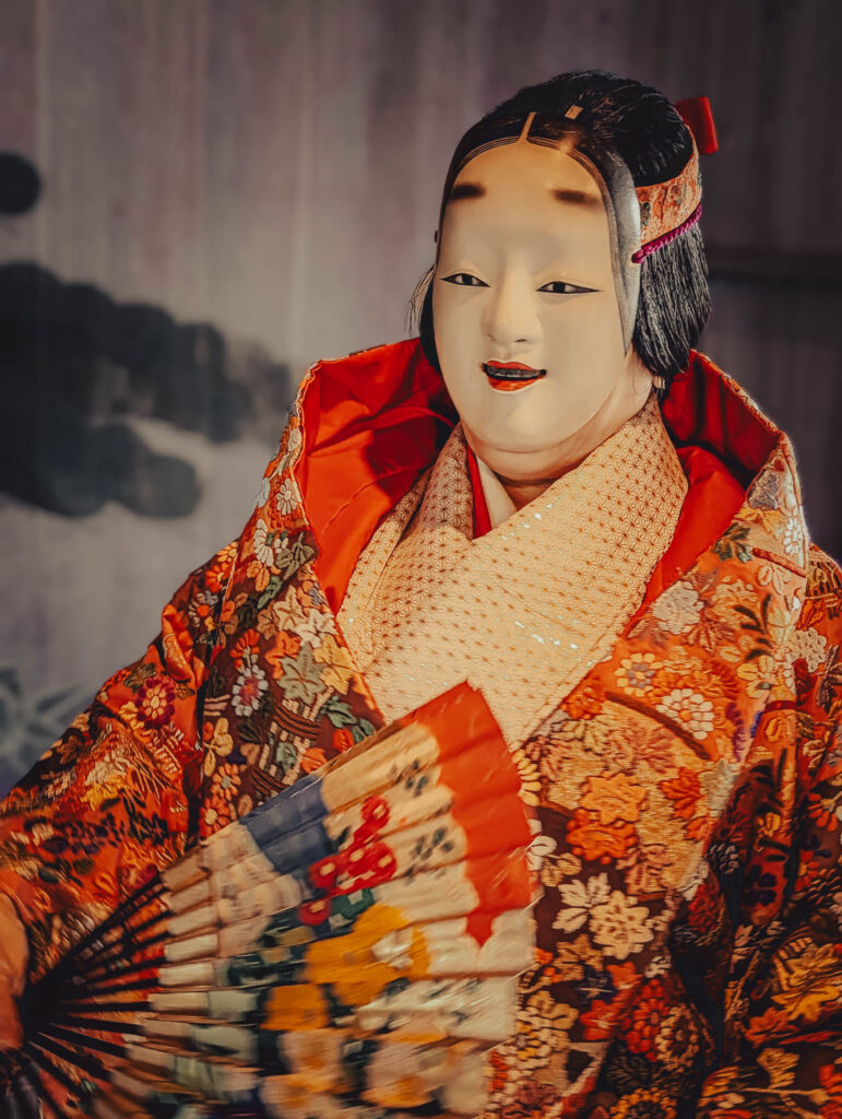 Sado Daizen Shrine Noh Stage, Takeda, Sado Island, rebuilt 1846 (Nov. 6, 2025): KY wearing antique 万媚 (Manbi, demon disguised as a young woman) nō-men and Karaori robe, with ōgi fan.