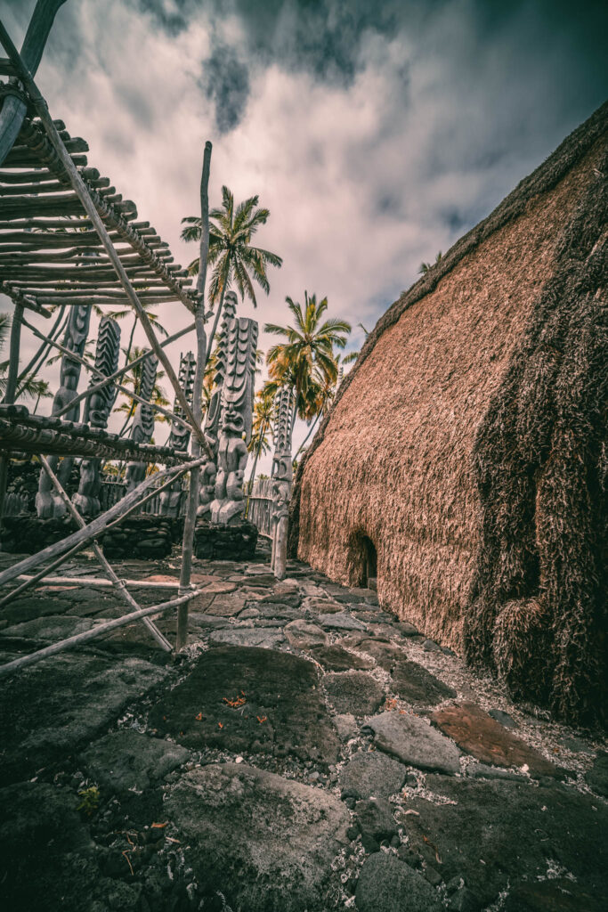 Puʻuhonua o Hōnaunau National Historical Park, Hōnaunau, Hawai'i (photo August 21, 2021): Hale o Keawe (thatched mortuary temple built by or for ruler Keawe-i-kekahi-aliʻi-o-ka-moku c.1700, last restored 2004) with recreated ki'i (divinity statues) and lele (a wooden offering tower or sacrificial altar).