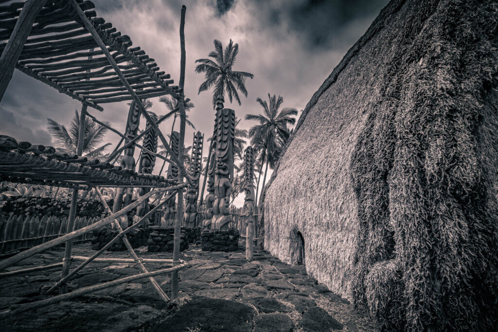 Puʻuhonua o Hōnaunau National Historical Park, Hōnaunau, Hawai'i (photo August 21, 2021): Hale o Keawe (thatched mortuary temple built by or for ruler Keawe-i-kekahi-aliʻi-o-ka-moku c.1700, last restored 2004) with recreated ki'i (divinity statues) and lele (a wooden offering tower or sacrificial altar).