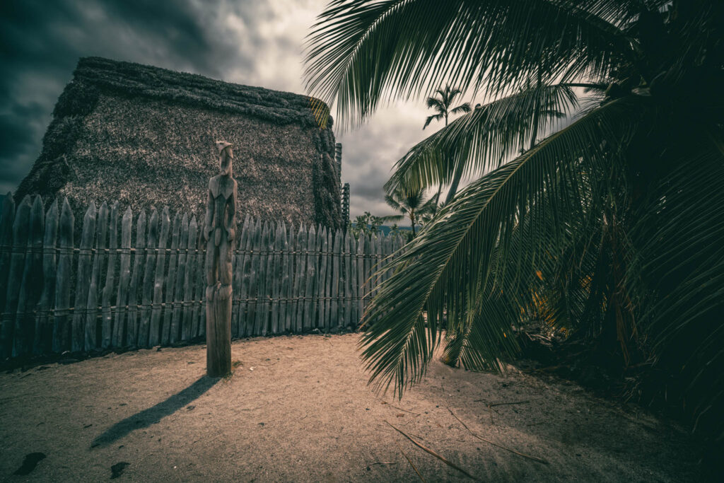 Puʻuhonua o Hōnaunau National Historical Park, Hōnaunau, Hawai'i (photo August 21, 2021): Hale o Keawe (thatched mortuary temple built by or for ruler Keawe-i-kekahi-aliʻi-o-ka-moku c.1700, last restored 2004) with recreated ki'i (divinity statue).