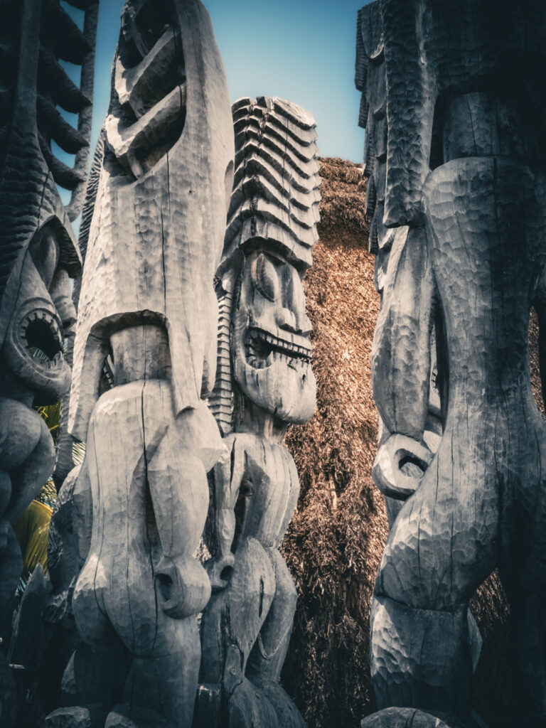 Puʻuhonua o Hōnaunau National Historical Park, Hōnaunau, Hawai'i (photo August 21, 2021): recreated ki'i (divinity statues) in front of Hale o Keawe (thatched mortuary temple built by or for ruler Keawe-i-kekahi-aliʻi-o-ka-moku c.1700, last restored 2004).