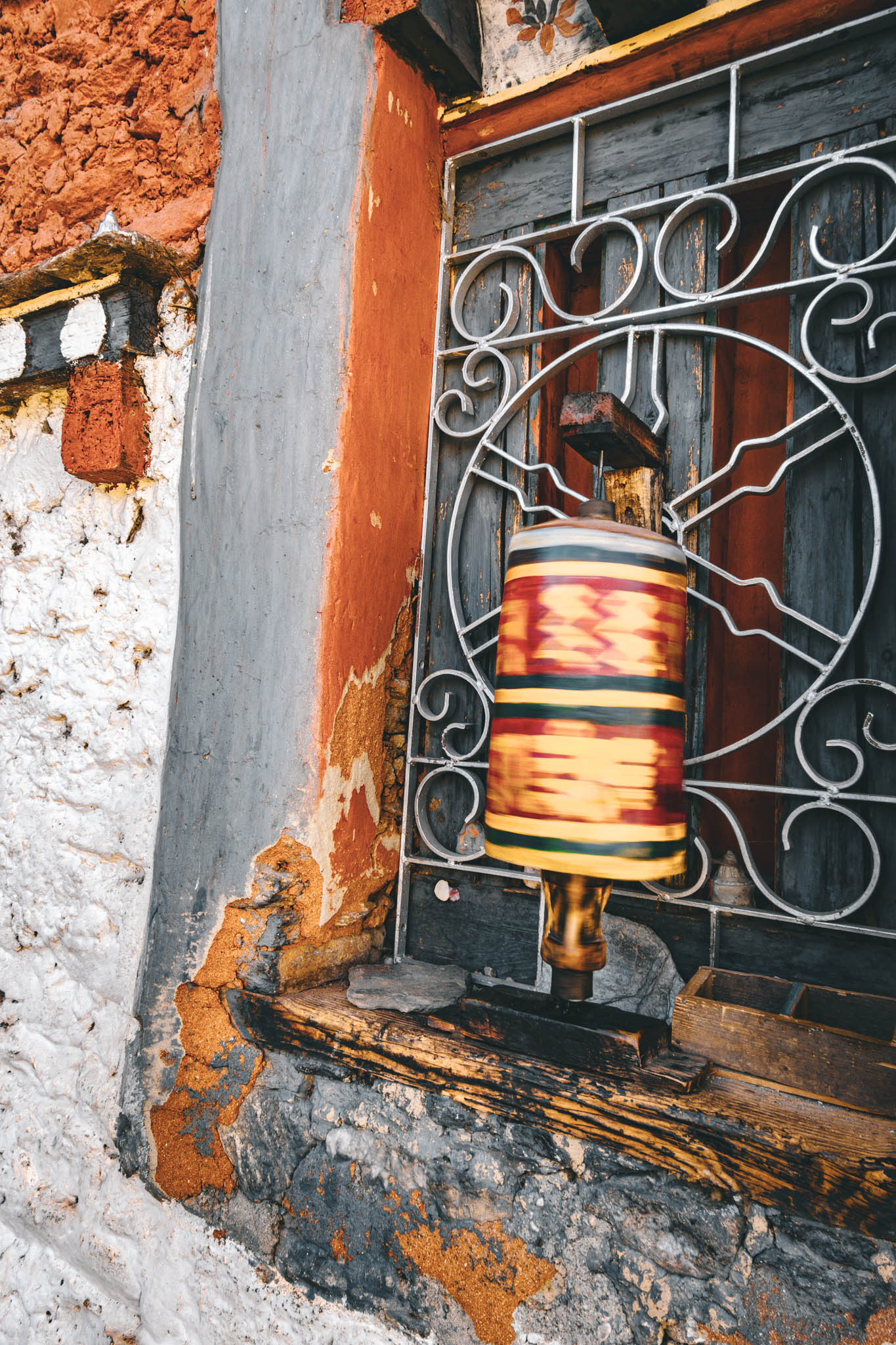 Jambay Lhakhang, Bumthang Valley, Bhutan, orig. 659 AD (photo Oct. 26, 2018) exterior window with "'khor lo" prayer wheel.