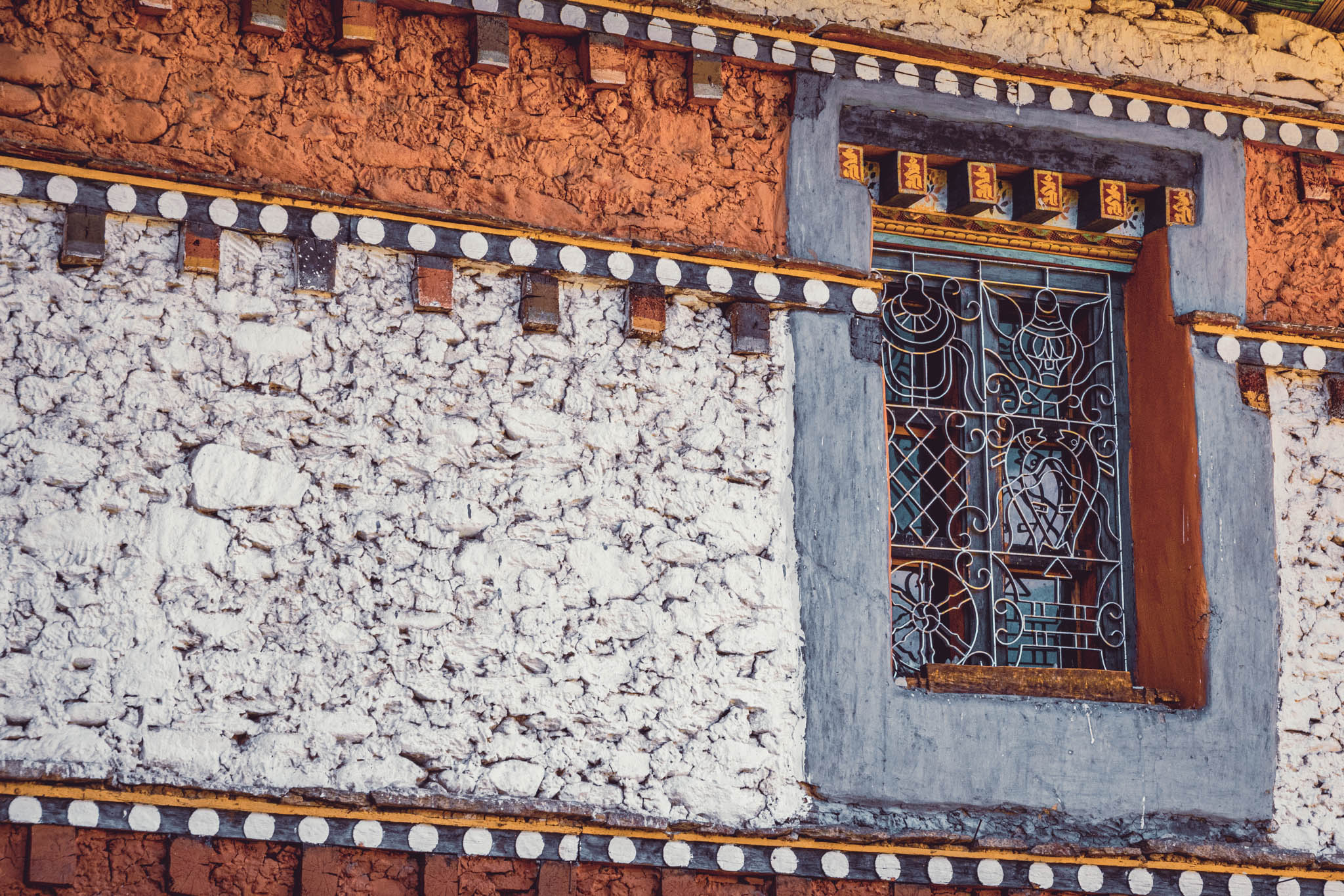 Jambay Lhakhang, Bumthang Valley, Bhutan, orig. 659 AD (photo Oct. 26, 2018) exterior window against kemar (decorative band of orange-red).