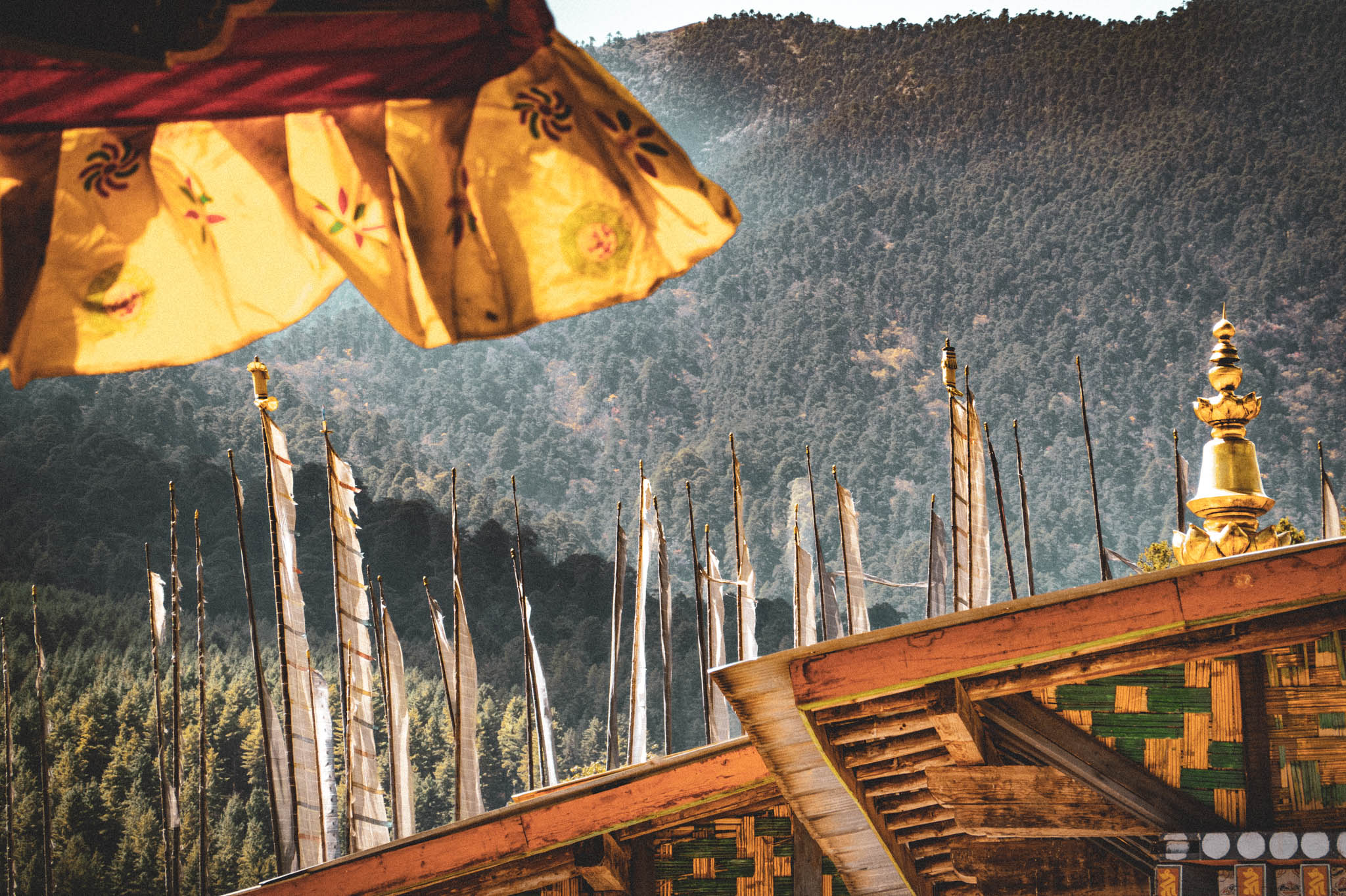 Jambay Lhakhang, Bumthang Valley, Bhutan, orig. 659 AD (photo Oct. 26, 2018) "darchog" vertical prayer flags beyond temple roofs.