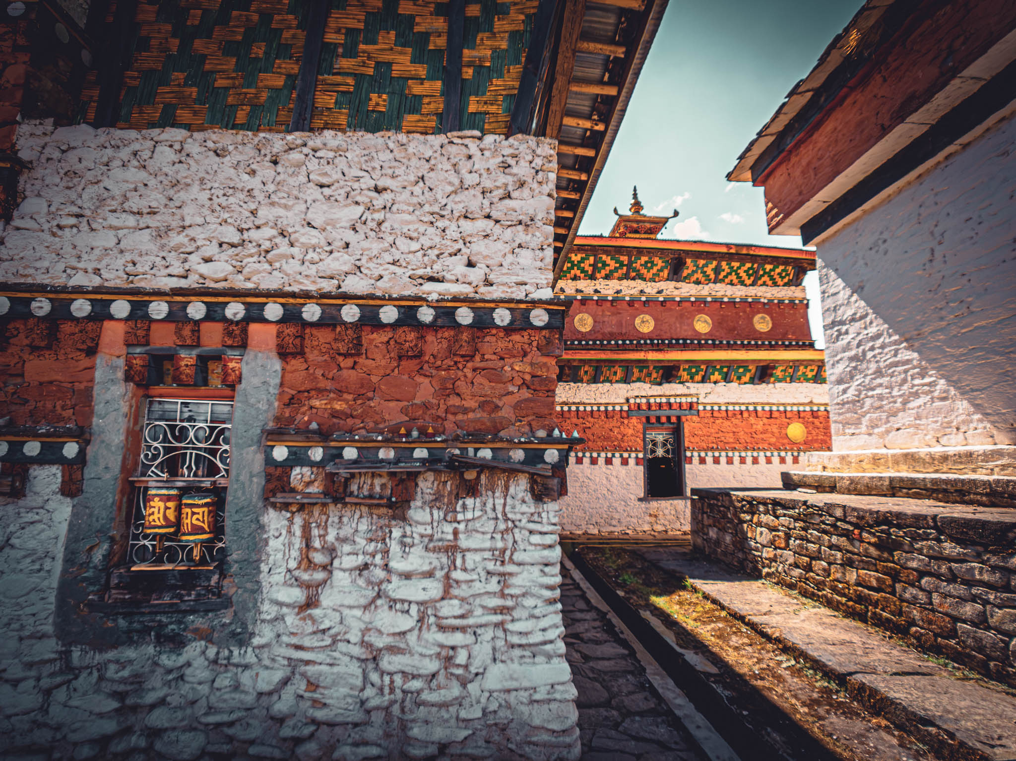 Jambay Lhakhang, Bumthang Valley, Bhutan, orig. 659 AD (photo Oct. 26, 2018) west exterior: corner of original Jampa Lhakhang (left), later Guru Lhakhang (center), and chorten (right).