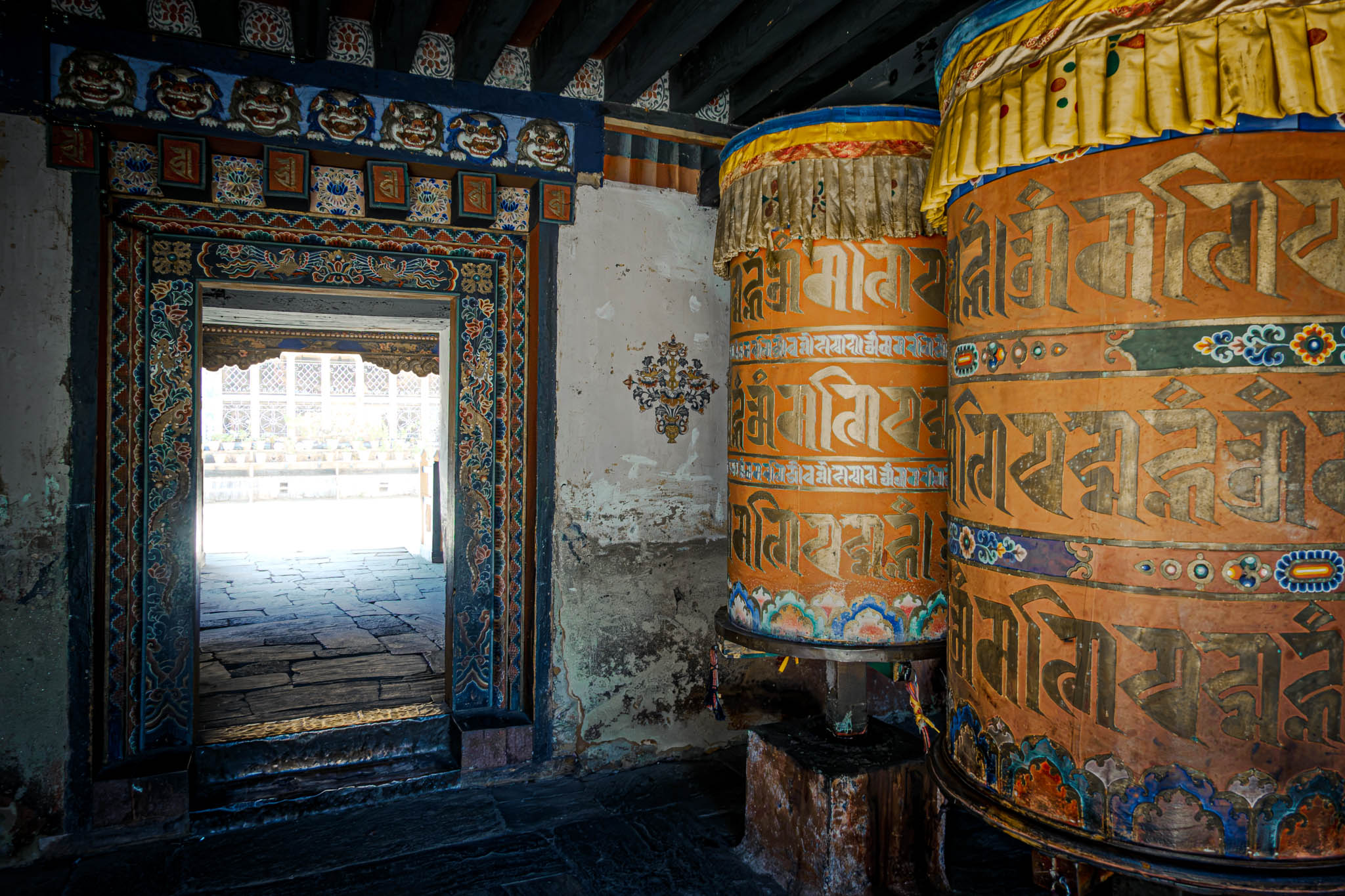Jambay Lhakhang, Bumthang Valley, Bhutan, orig. 659 AD (photo Oct. 26, 2018) entrance to courtyard vestibule with "'khor lo" prayer wheels.