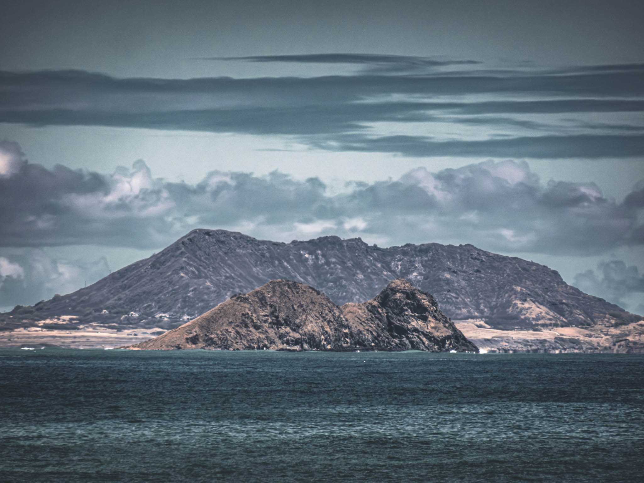 Moku Iki and Mokula Islets (near) with Mokapu Point and Ulupa'u Crater (far background) from Makapuʻu Lookout, Kalanianaʻole Highway, Oahu Island (photo 17 August 2021).